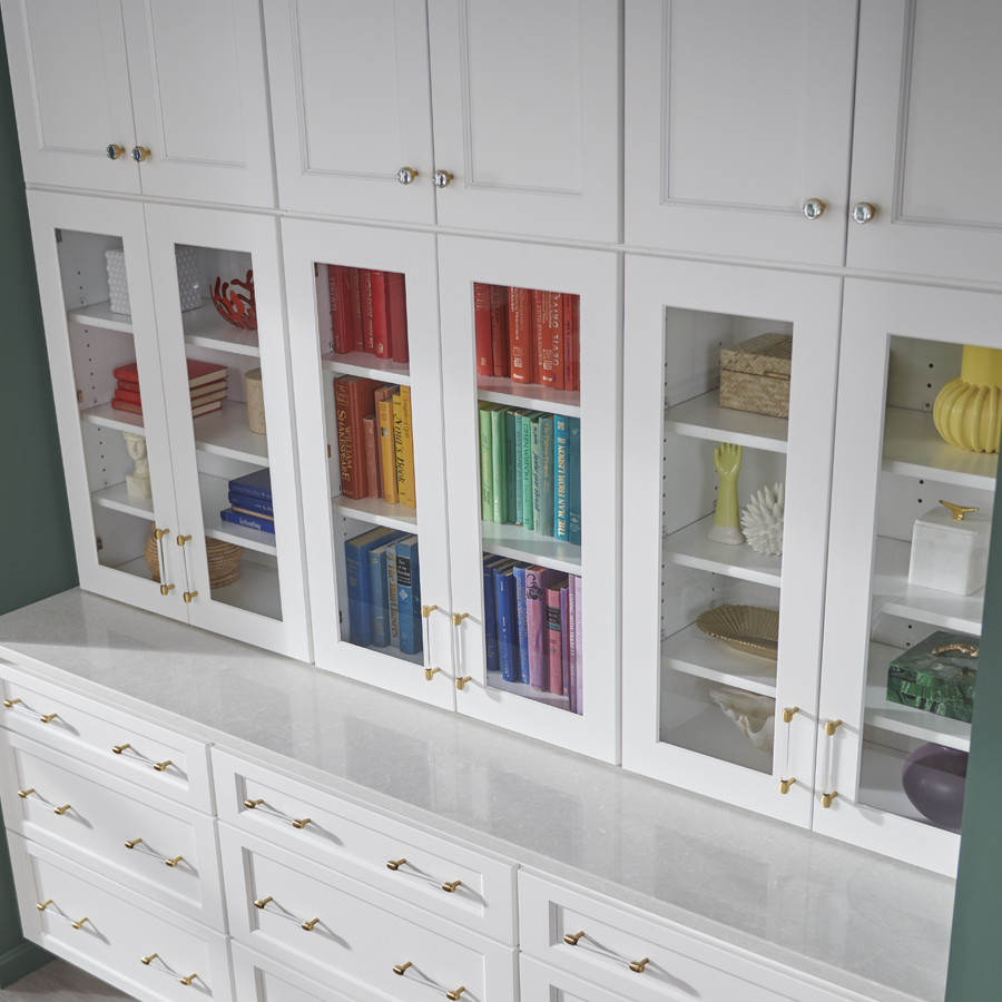 a cabinet bookshelf with a rainbow of books on it