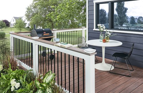 a deck featuring Wolf railing with a table and chairs and a grill