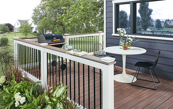 a deck featuring Wolf railing with a table and chairs and a grill