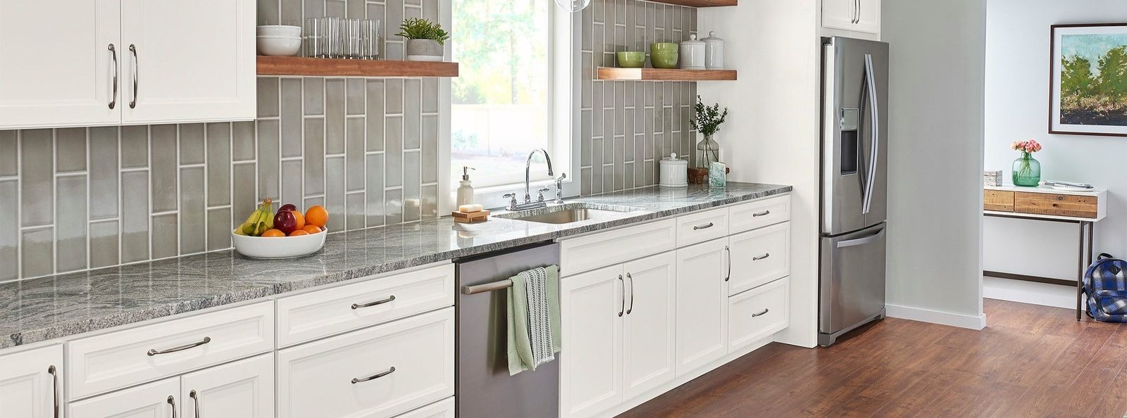 a kitchen with white Wolf Signature cabinets and a stainless steel refrigerator