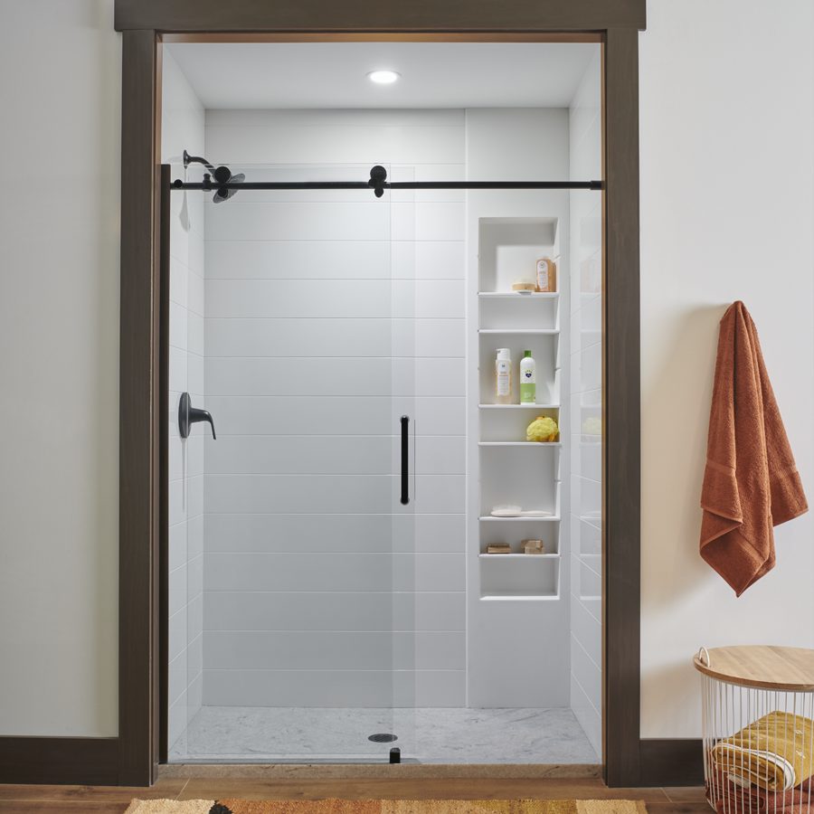 a bathroom with a Wolf shower with a sliding glass door and a towel hanging on the wall