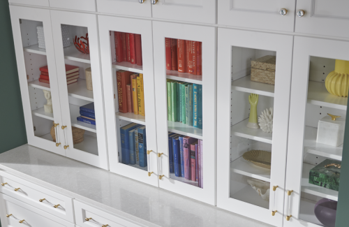 a cabinet bookshelf with a rainbow of books on it