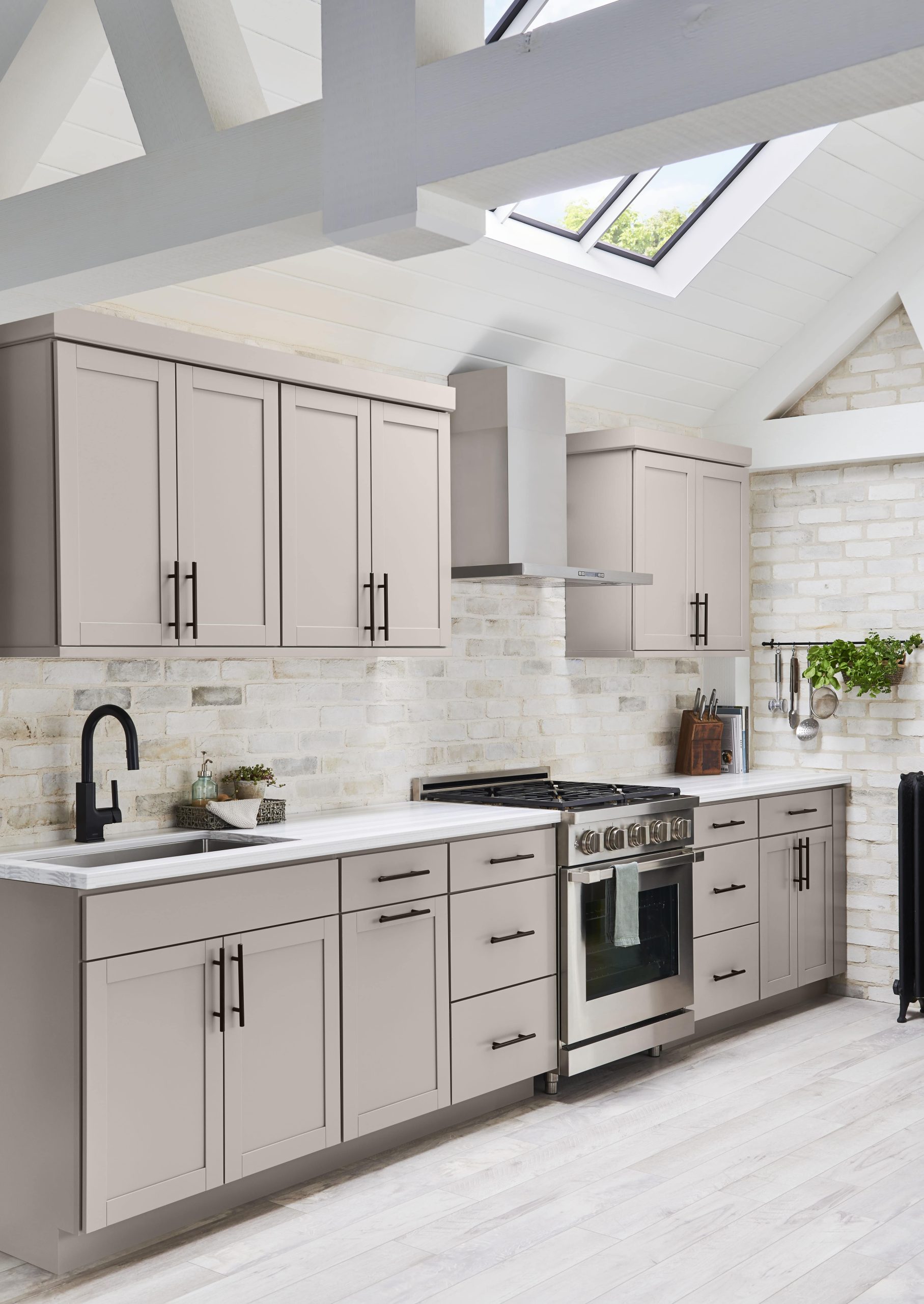 a kitchen with gray cabinets and stainless steel appliances